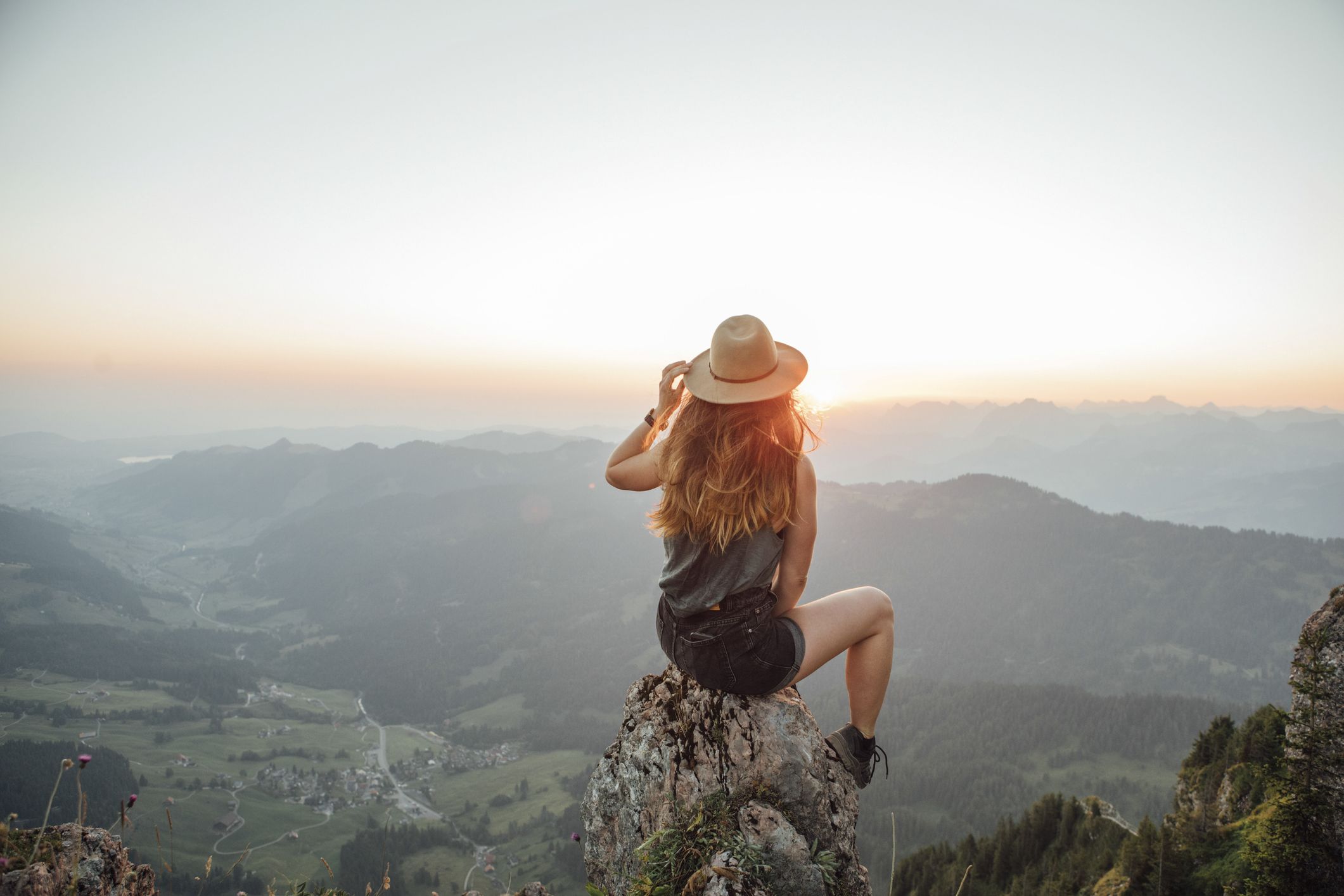 Femme contemplant un paysage de montagne, symbole du temps pris avant une nouvelle étape.